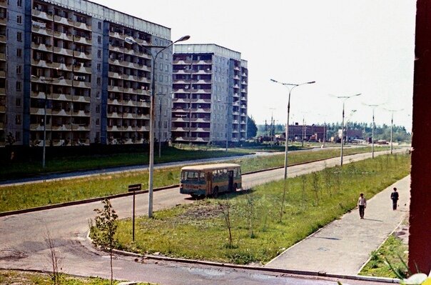 Фото Алексея Михайлова, лето 1987 г. Слева направо мы видим здания:  - ул. Петрова, 4 - 1983 года постройки; 
- ул. Петрова, 2 - 1983 года постройки; 
- канализационная насосная станция №5 (Ленинский просп., 11) - 1984 года постройки; 
- тяговая подстанция УТТ (Ленинский просп., д. 11А) - 1987 года постройки. Автобус на фото - ЛиАЗ-677, выпущен не позднее 1980 г.
