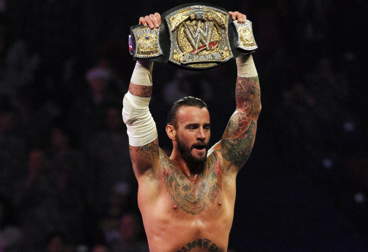 Позирует с чемпионским поясом WWE