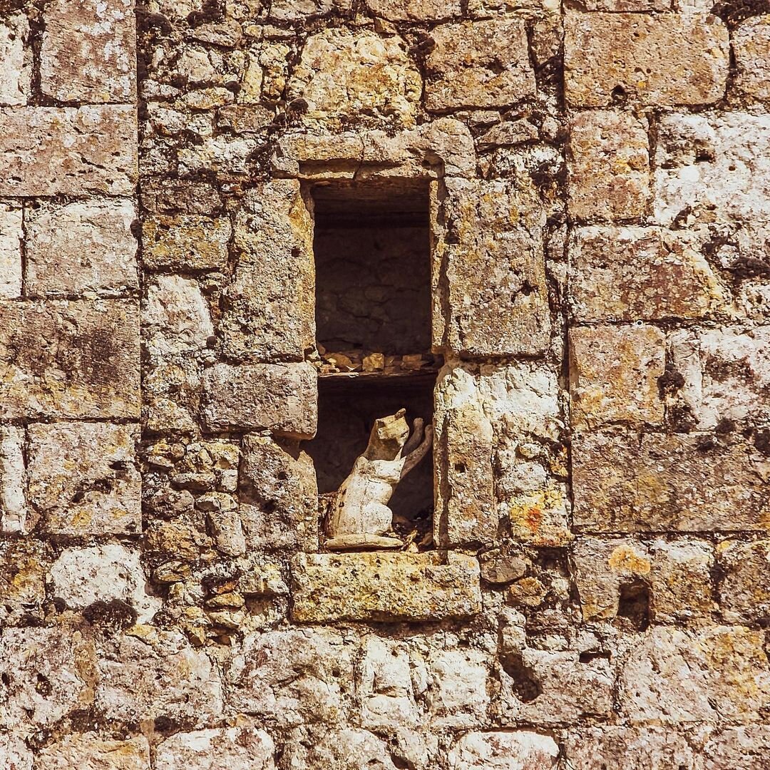 Скульптура кошки в нише городской стены