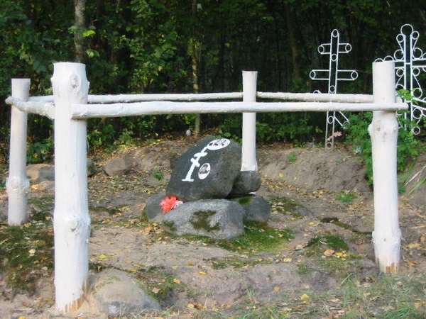 На камне две фотографии. Одна  родительская, а другая дедушки. Его нет там, он расстрелян был.  В 1937 году. Но я взяла  - у нас  под Петербургом - , с места расстрела землю. Перевезла сюда, сделала фото.