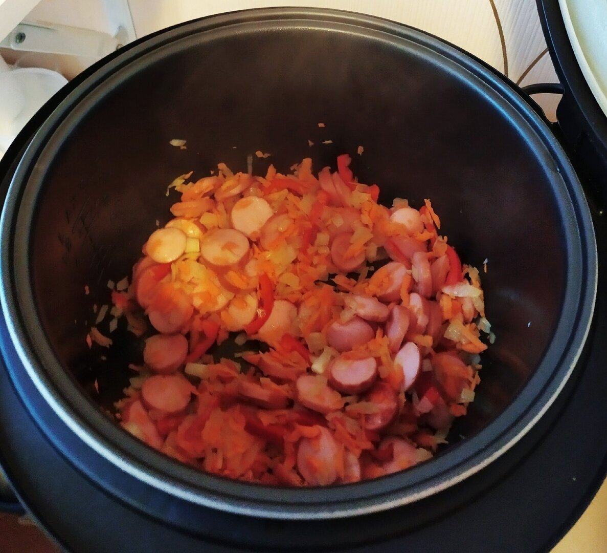 Нашинковать морковь и лук, порезать мясо или сосиски и обжарить все на растительном масле