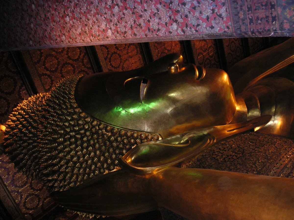 Фигура лежащего Будды в храме “Ват Пхо” или “Храм лежащего Будды”, ожидающего нирваны. Буддийский храм в центре Бангкока, в Таиланде. Фото автора статьи. 