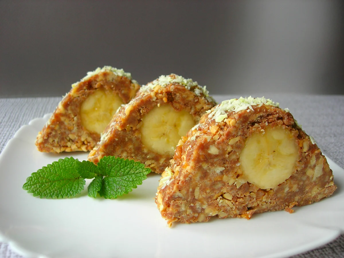 Сегодня будем делать интересное печение без выпечки ,которое называется «Карпаты» Продукты нам понадобятся абсолютно простые  , доступные  любому человеку . Рецепт очень лёгкий в приготовлении не занимает очень много времени , а вкус вас приятно удивит. И будет одним из ваших любимых лакомств к утреннему чаю перед работой или просто для сладкоежек кто  решит себя и близких порадовать  приятным необычным лакомством на скорую руку .
Вот рецепт нам понадобятся продукты

Печенье  любое  можно со вкусом топлёного молока - 200 грамм
Арахис жареный   можно  орехи грецкие  – 100 грамм
Шоколад  можно любой но вкуснее с горьким получается – 1 плитка (90 грамм)
Банан (большой) – 1 шт.
Сливочное масло – 100-150 грамм
Коньяк – 1 ст. л.  не обязательно 
Кокосовая стружка – 4 ст. л. (не обязательна)

Растапливаем шоколад со сливочным маслом  в кастрюльке .Печенье и орехи размягчить в крошку с помощью скалки или блендером. Растопленную шоколад  смешиваем переливаем в тарелку  вместе с  печеньем ,орехами и всё хорошо перемешиваем . Берём фальгу   на него слоем размещаем  готовую смесь разравниваем слой и сбрызгиваем коньяком  (можно и без коньяка ) Посередине делаем углубление  вкладываем туда банан  и начинаем формировать форму . Формируем форму в виде горы и отправляем в холодильник на 2 на 3 часа  что бы масса  хорошо застыла и легко нарезалась . Через несколько часов достаём из холодильника  разворачиваем фольгу и нарезаем на порции . Получаются полноценные пироженое и выкладываем каждому на тарелку . Вот и всё десерт готов к употреблению с чаем .Приятного вам чаепития .Приготовьте своим близким и родственникам ,думаю им понравиться .Ставьте лайки пишите комментарии.