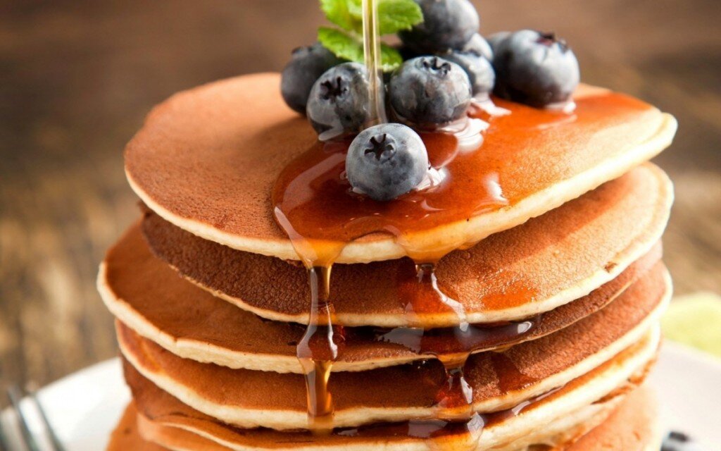 Это стопка классических Американских панкейков. Они полюбились жителям США и Канады в качестве утренней трапезы. В основном их подают с кусочком сливочного масла, клиновым сиропом, украшают ягодами и нарезанными фруктами на любой вкус и цвет. Блаженный завтрак.