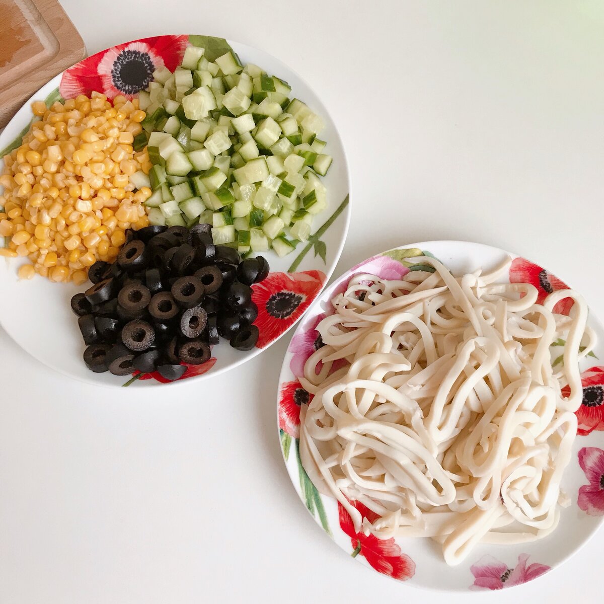 Варёные кальмары режем полукольцами, огурец небольшими кубиками, а маслины колечками