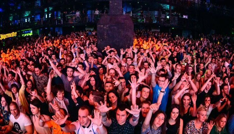  
          В этой серии расскажу моё субъективное понимание самой программы дискотек. Любая дискотечная шоу программа, как то танцоры, диджеи, мини шоу – всё это стоит денег. И клуб конечно же старается минимизировать затраты при максимуме отдачи. Нет смысла ставить дорого диджея и супер танцовщиц гоу-гоу на дискотеку среднего класса, но по правилам современной дискотечной программы на сцене 50% времени должна быть команда, которая своей энергией и движениями заводит тусовку для коллективного танца. И тут у клубов среднего класса, особенно в провинциальных городах России, возникает вопрос - каким образом заполнить сцену танцевальными недорогими и активными командами. Вопрос решается просто – клуб сам по себе это отличное тёплое помещение, которое простаивает в будни и дни большое количество времени. И клубу стратегически выгодно держать у себя многочисленные секции современного дискотечного танца, где все желающие из города могут массово заниматься бесплатно. При этом клуб тратится на небольшую зарплату преподавателям современного дискотечного танца, и всяческим образом привлекает молодых самородков преподавателей танца, которые просто физически не могут оплатить аренду для занятий своих команд, это все стили современного танца, включая стрип-пластику и гоу-гоу. И соответственно эта команда, занимаясь танцами, бесплатно на клубной площадке, по правилам хорошего тона, должна платить оброк клубу своими танцами на сцене за небольшие деньги. И это выгодно как клубу, так и самим танцорам, которые таким образом набирают опыт работы на сцене. Это тоже самое, что и чирлидеры в спорте, никто ведь не платит этим университетским командам большие гонорары, но все довольны, потому что девочки рекламируют себя, занимаются спортом танцами гимнастикой, а зрители получают эстетическое удовольствие от их танца на поле. Даже самые дорогие клубы Москвы обязательно позволяют заниматься танцовщицам на своей площадке, потому что очень заинтересованы в постоянной тренированной и слаженной команде по вменяемым ценам.    Про музыкальную программу: хорошие диджеи на вес золота, те кто чувствует танцпол, кто может его раскачать с нуля. Дижей может разогреть, притушить, заставить перегреться, и довести до романтических слёз разогретую толпу. Важно понимать ещё так называемые циклы Кребса и регуляция гликолиза в организме, когда средний не тренированный человек, не может танцевать без перерыва быстрые танцы более 40-45 минут. Постоянная долбёжка однотипной музыки перестаёт восприниматься и стимулировать публику, именно поэтому на транс тусовках принимают употребляют препараты вводящие в другое измерение. Но мы категорически против стимуляторов, кроме разрешённого лёгкого алкоголя, и то лучше даже обходиться на танцах и без него. Так вот для того чтобы не было занудства, необходимо менять темп, и для этого подходит несколько вариантов. 
1) Конкурсы с призами на сцене, которые проводит ведущий, пытаясь привлечь саму публику. При этом необходимо вызвать интерес зрителей, поэтому часто конкурсы проводятся с эротическим подтекстом, либо на демонстрацию возможностей посетителей.
 2) Два три медленных танца, которые дают отдохнуть публике, пойти выпить в баре, а некоторым осуществить свою мечту и подойти к девушке, пригласить её на танец. Многие клубы средней руки игнорируют медленные танцы, беря пример с Европы, считая это колхозной темой, типа это не круто. Но забывают (или вообще даже не знают), что танцы без перерыва в европейски клубах проходят под потребление 70% посетителями - экстази и амфетаминов и прочих более тяжёлых стимуляторов нервной и гормональной активности. В России, и это очень хорошо, массовое потребление веществ стимуляторов не распространено, поэтому схемы дискотечных программ, когда быстрый бит идёт и три и четыре часа подряд, дают сбои, толпа устаёт, теряет интерес к танцу, и садится по углам и столикам. Когда я сам давным давно работал дижеем, я чётко знал, что если хочешь прибить весёлую атмосферу танцпола, то нужно просто загнать толпу как лошадь, прокручивая быстрый бит композиций в течение часа – полутора. 
3) Шоу танцоров типа циркового, когда толпа завороженно смотрит на сцену. Клубы высокого класса предпочитают именно вариант зрительного танцевального шоу. Диско клубы 70-х 80-х предпочитали выступление живого певца, исполнителя танцевальной музыки. В целом по уровню танцовщиц и танцевальных команд можно сделать вывод об уровне и бюджете клуба. 
               Но нельзя забывать главного, несмотря на красивых танцовщиц, посетители пришли себя показать и других посмотреть, а также познакомиться. И поэтому если не будет достаточно девушек посетителей (хотя бы 30%), то вся программа становится не такой уж весёлой. Как ни странно это звучит, но именно на вечерние программы приходит много девушек, интересных посетителям именно для знакомства, а на ночную программу приходит их в три-пять раз меньше, и то большей частью постоянные клубные девушки тусовщицы, которые не так уж просты на знакомства. 
                   В своё время автор и хозяин системы «Мегадэнс» Сергей Филиппыч, сделал хорошее распределение в своих клубах потоков посетителей по возрастам. 
1) Днём в субботу и в воскресенье с 14:00 до 18:00 проходили дискотеки для школьников с 11 до 16-ти лет, они проходили строго без продажи алкоголя в баре. Посещаемость в клубе Шоссе в среднем в сезон была 1600 чел. в субботу и 1200 чел. в воскресенье. Кто-то подумает, о какой ужас, от этого же упадёт престиж клуба, в него не пойдут взрослые люди!!! Но практика показала обратное, школьники активным образом делали рекламу клубу, и мало того помогали раздавать флаера на взрослые ночные программы. Да, часть школьников пила пиво перед дискотекой, покупая его в магазинах, но это не проблема клуба, тем более если уж очень были видны следы опьянения, то подростка просто не пускали в клуб. По факту выпивших подростков было не более 2% от общего количества. И поверьте мне, эти дискотек были самыми энергичными и веселыми. Был ещё один эффект от этих программ, это разогрев клуба этими дневными и пропитка его феромонами молодости, то есть когда заходят первые посетители в 19:00 то они очень хорошо чувствуют что основной и весь клуб очень хорошо разогрет, так как будто они пришли в 2-а ночи, и это помогает хорошо запустить и субботнюю и пятничную программу. 
2) Вечер четверг, пятница, суббота – это самые массовые программы, потому что по четвергам приглашаются ВУЗы по бесплатному входу в первый час. В четверг и пятницу приходят много новых людей, это знают постоянные посетители и очень любят посещать именно четверги и пятницы, потому что видят там не клубных девушек студенток, с которыми активно знакомятся.          Воскресенье вечер не самая массовая программа, но как ни странно, во время работы менеджером клуба, я знал немало посетителей которые ходили в клуб только по воскресеньям, потому что по субботам у них были дни рождения и домашние вечеринки друзей и выезды за город.
 Суббота вечер, самое козырное время. Хотя клуб начинает работать зимой с 19:00, но многие посетители приходят часам к девяти десяти, чтобы застать публику и вечернюю и ночную и снимают двойные сливки. Некоторые дорогие ночные клубы, принципиально не делают вечерних программ, и разогреваются только часам к 2-м ночи, когда к ним из ресторанов съезжается разогретая мажорная публика. При этом в это время, когда бар, в клубах с вечерними программами, сделал уже 60% от общей кассы, они только начинают входить в оборот за счёт выданных депозитов на входе в клуб (лично я против барных депозитов на входе, это насилие над посетителем, исключение составляют только депозиты на столики ресторана в клубе). На том , что некоторые ночные клубы не проводят вечерние программы, они теряют кассу, но менять ничего не хотят, потому что считают вечерние программы для себя не престижными. По моим личным наблюдениям, именно вечерняя программа до 24:00 собирает множество девушек, а уже после полуночи они разъезжаются либо на метро, либо на такси.
3) Ночные программы пятница и суббота ночь. По моему практическому опыту, ночь пятница только тогда идёт хорошо, когда вечером в этот пришло много посетителей. Если на вечерней программе было 900-1500 посетителей (в основном приглашенные ВУЗы), то на ночную программу точно останется 500-700 человек до трёх ночи. 
     Суббота ночь это самая массовая вечеринка, пик посещения обычно с 22:00 до 01:00. Суббота это самая большая касса бара, и из-за большой массы взрослых посетителей, самая энергичная тусовка. Ни о каких ночах в понедельник, вторник и среду речи быть не может, максимум это работа клуба допоздна по факту, если только собралась большая тусовка и видно что они так разогрелись на программе, что не хотят расходится по домам после стандартных 23:00. Либо же эт предпраздничный день, перед группой выходных. Именно жадность горе промоутеров, которым клубные менеджеры отдавали большие проценты от бара за такие программы, и прибила эти студенческие программы. ВУЗы перекормили этими ночными мероприятиями, и они перестали на них реагировать. Всё вернулось на круги своя, как в 1996 году, работа по ВУЗам конечно есть, но массово привести весь ВУЗ в клуб теперь не представляется возможным. Тем более вступил такой фактор, как большая «разношёрстность» студентов, некоторых в клуб пускать категорически запрещено. Продолжение следует…….
