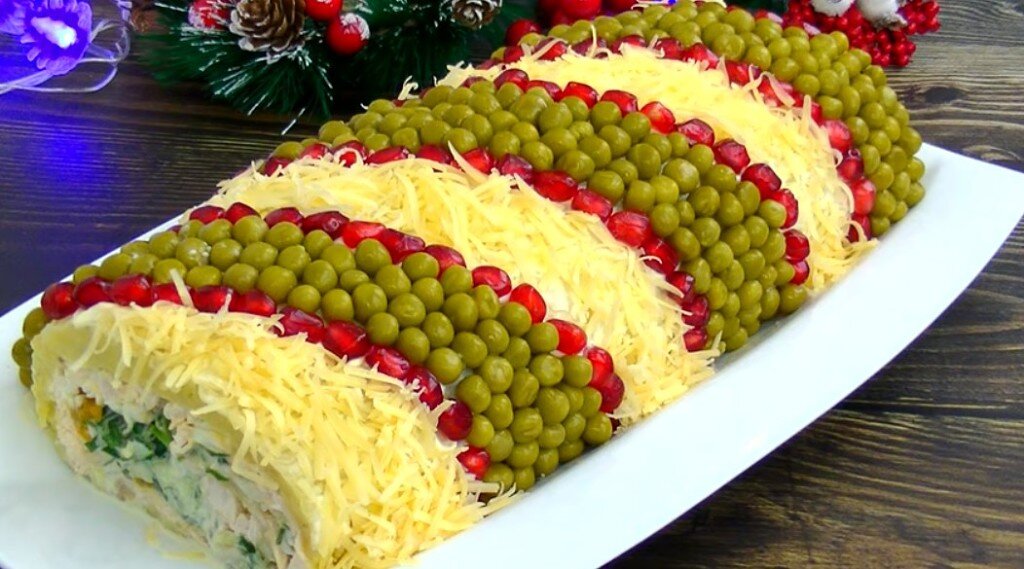 Изумительно красивый и вкусный салат на новогодние праздники «Король стола» Приготовьте его на Новый Год и пусть ваши гости обалдеют!
Ингредиенты:
250-300 г куриного филе;
5-6 картошек;
4 куриных яйца;
4 свежих огурчика;
50 г перетертых грецких орешков;
50 г кураги или чернослива;
Майонез для заправки.
Для украшения салата:
Баночка консервированного горошка;
Твердый сыр;
Пучок кинзы;
Гранат.
Приготовление:
Для начала отварите, картошку, курицу и яйца.
Картошку, яички, огурчики крупно натрите на терке, курицу и сухофрукты порежьте маленькими кусочками.
Затем возьмите большую прямоугольной формы тарелку, накройте ее пищевой пленкой и приступайте к выкладыванию ингредиентов:
Важно! Прямоугольная посуда позволит салат скрутить в рулет.
Слой 1 – картошка, плотно уложите и промажьте майонезом;
Слой 2 – куриное филе, утрамбуйте и снова майонез;
Слой 3 – яички, промазать майонезом;
Слой 4 – орехи с сухофруктами, снова майонез;
Слой 5 – свежий огурчик, смазываем майонезом.
Немножко присолите каждый ряд, кроме с орехами и сушеными фруктами.
Далее скрутите салатик в рулет и замотайте в пленку. Поставьте в холодильник на несколько часов.
Затем достаньте пропитанный салатик и промажьте со всех сторон майонезом. Ингредиенты для декора выложите немного диагональными полосами. Вначале горошек, а по его краям ряд из зерен граната, между ними тертый сырок и измельченная зелень.
Вот и все! Салат готов на Новый Год! Приятного аппетита!