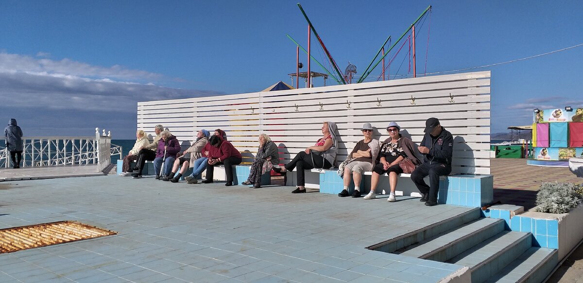 Пенсионеры загорают на солнышке.