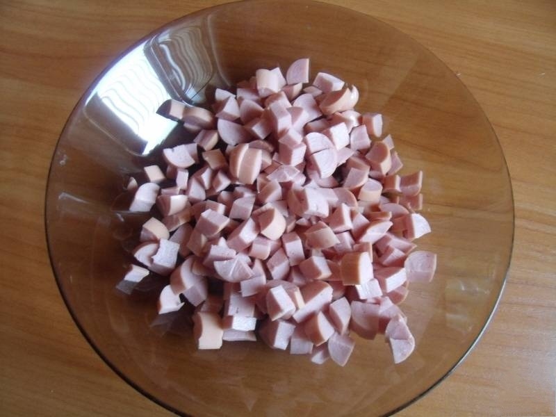 Сосиски нарезаем мелкими кубиками и выкладываем в глубокую миску.
