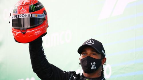 Льюис Хэмилтон снимает старый шлем Шумахера после того, как установил рекорд немецких побед в Формуле-1