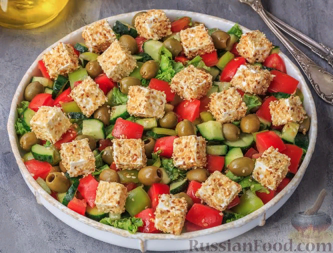 Привычный салат из свежих помидоров, огурцов и сладкого перца можно с легкостью превратить в эффектную и необычную закуску. Достаточно добавить в овощной салат немного оливок и кусочки сыра фета в панировке из жареного кунжута. Аппетитное сочетание солоноватого сыра, пикантной кислинки оливок, ароматного кунжута и сочных овощей соблазнит потрясающим вкусом и внешним видом любого гурмана. Попробуйте!