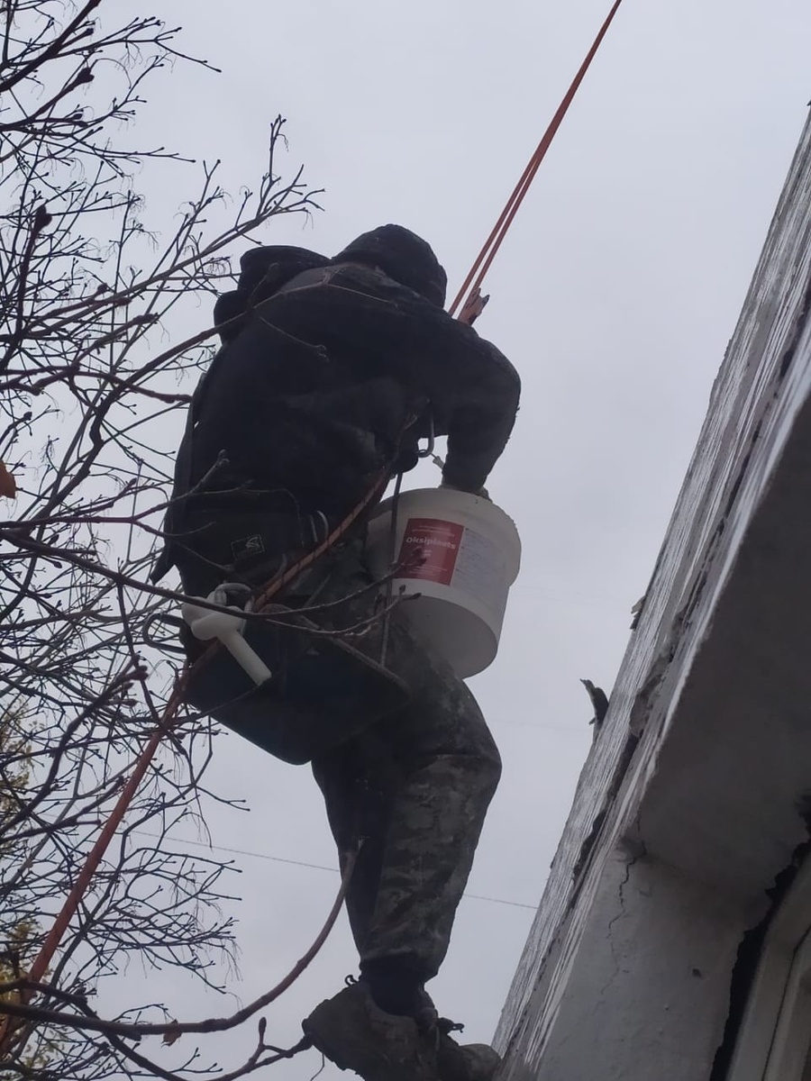 Альпинист выполняющий объем работ по устранению разрушений внешних герметизирующих стыков.