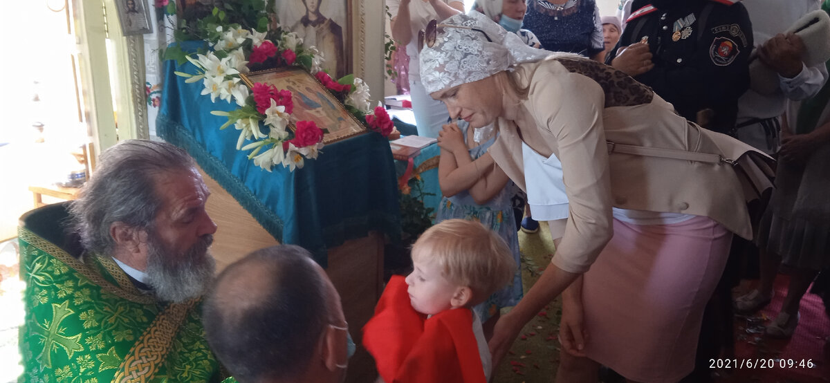 Батюшка Андрей деток причащает.