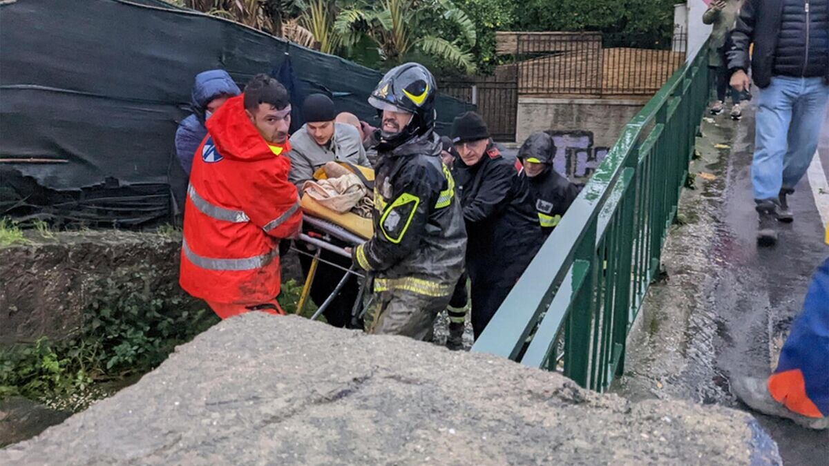    Итальянские пожарные выносят мужчину из его дома на юге острова Искья после схода оползня© AFP 2022 / Ansa