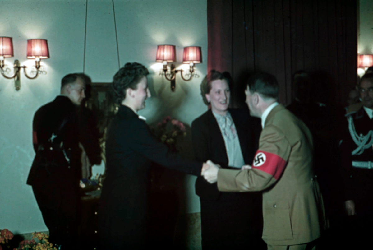  Адольф Гитлер улыбается, пожимая руку двум своим личным секретарям (Герде Кристиан и Кристе Шрёдер) в рейхсканцелярии вскоре после полуночи в день его 50-летия