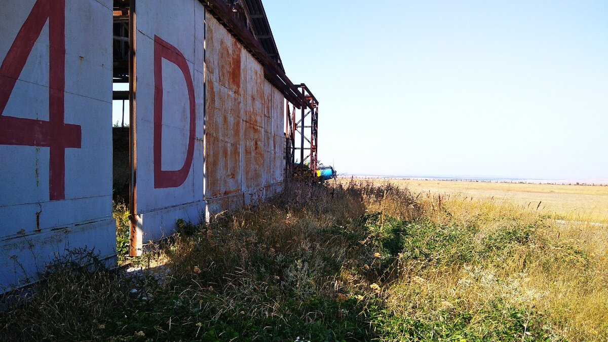 За ржавыми воротами - наша цель. Дальше за ангаром - один из летающих Ан-2.