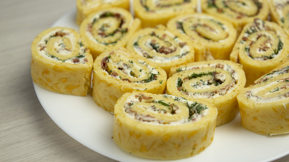 Если Вы решили удивить своих гостей разнообразными закусками, то можно приготовить сырные рулетики с беконом и творожным сыром.