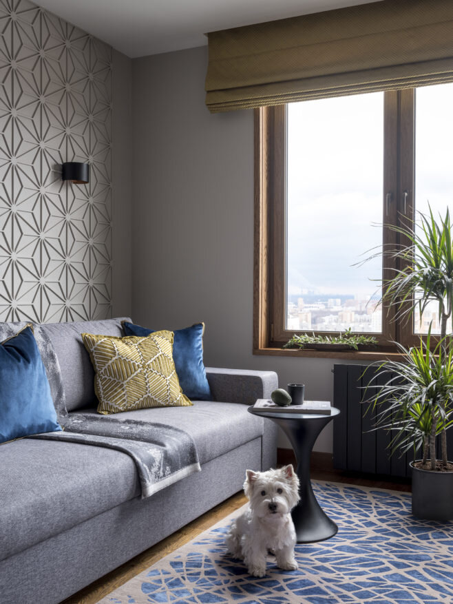 Гостиная. Диван, “Эстетика”; плед, L-Collection; подушки, римские шторы, журнальный столик, краска на стенах, все Apriori Home; ковер, Dovlet Hоuse; радиаторы Broner, “Арт-Технология”; бра, Donolux. Ажурная стена из гипса. Решетки притока и оттока встроены во всех комнатах в фасадные планки над системами хранения и занимают минимальное пространство, компания “Орлан”.