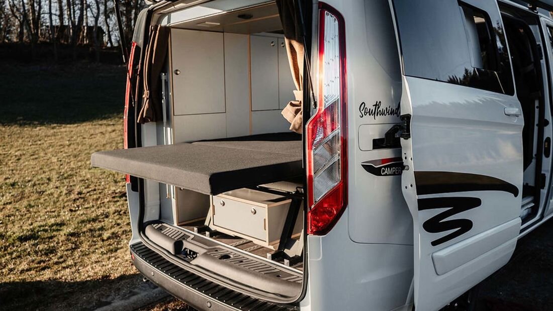 "Рельсы" на полу позволяют дивану-кровати перемещаться вдоль салона и с открытым багажником организовать зону "релакса" на природе.