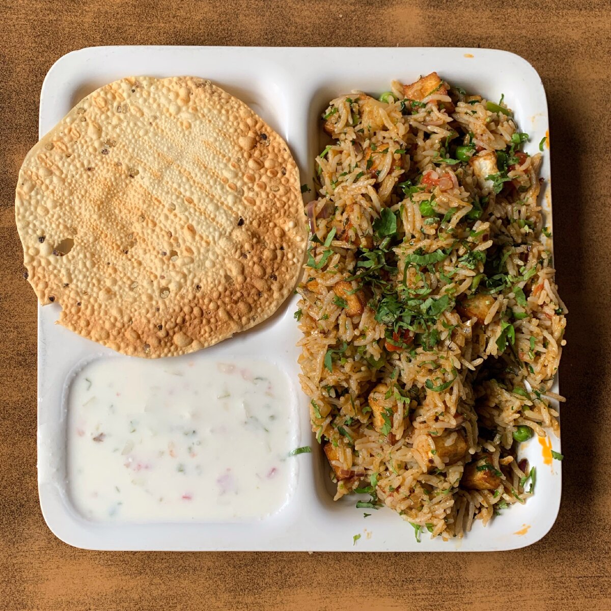 На фото рис с овощами и паниром, йогуртовый соус, хрустящая лепёшка - пападамс.