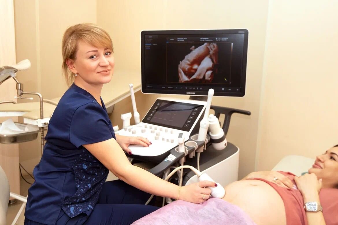 Врач МДЦ "ДАВИНЧИ" проводит процедуру ультразвуковой диагностики беременной пациентке.