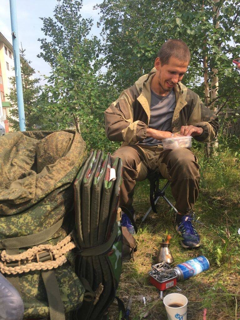 В дороге питерский путешественник постигает азы бариста. В рюкзаке у него всегда есть молотый кофе и медная турка. Кстати, в Салехарде он первым делом сварил кофе, удобно расположившись на лужайке напротив редакции «Красного Севера». Фото: Екатерина Золотарёва / КРАСНЫЙ СЕВЕР