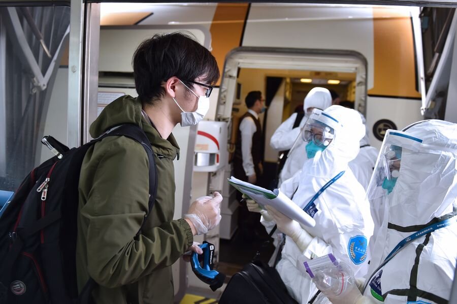 Таможенник опрашивает пассажиров в аэропорту Пекин Шоуду 18 марта 2020 года (Фото: Xinhua/Chen Zhonghao)