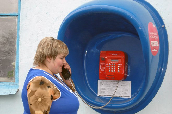 Женщина пользуется таксофоном для совершения звонков. Фото из открытых источников "Яндекс.Картинки".