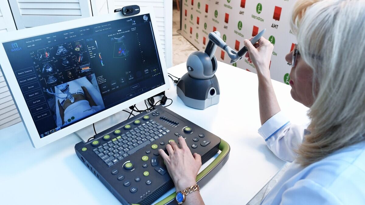    Специалист по ультразвуковому исследованию за органами контроля и управления телемедицинской роботизированной установкой для удаленного ультразвукового исследования© РИА Новости / Сергей Пятаков