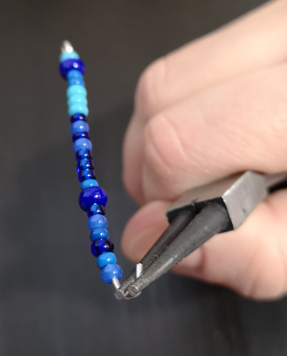 Нанизываем в произвольном порядке бусины и загибаем свободный конец (но не до конца)