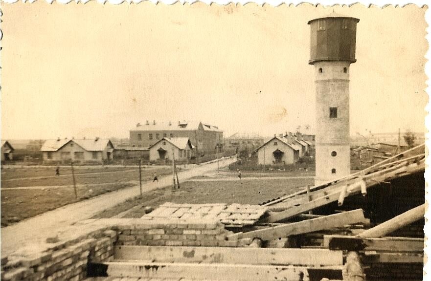 Вид на улицу Школьная с крыши строящегося клуба. Слева видно здание школы и жилые дома пересечения улиц Пионерской и Школьной. Справа — водонапорная башня. Конец 50-ых гг. ХХ века.