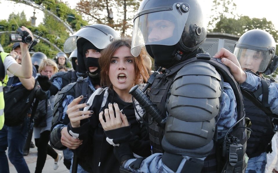 Полиция уводит активистку в Автозак.