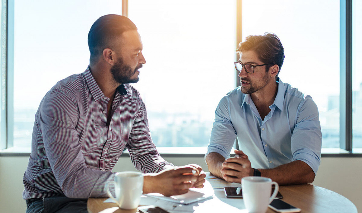 Два деловых человека. Стильно фон коучинг. Man talking. Business talk. Businessman talking to colleagues in meeting.