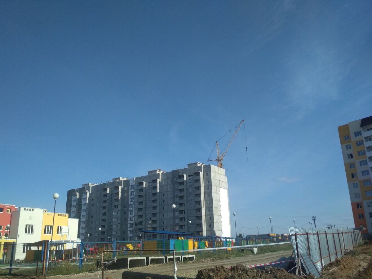 На доме вдали, справа видно делают утепление.