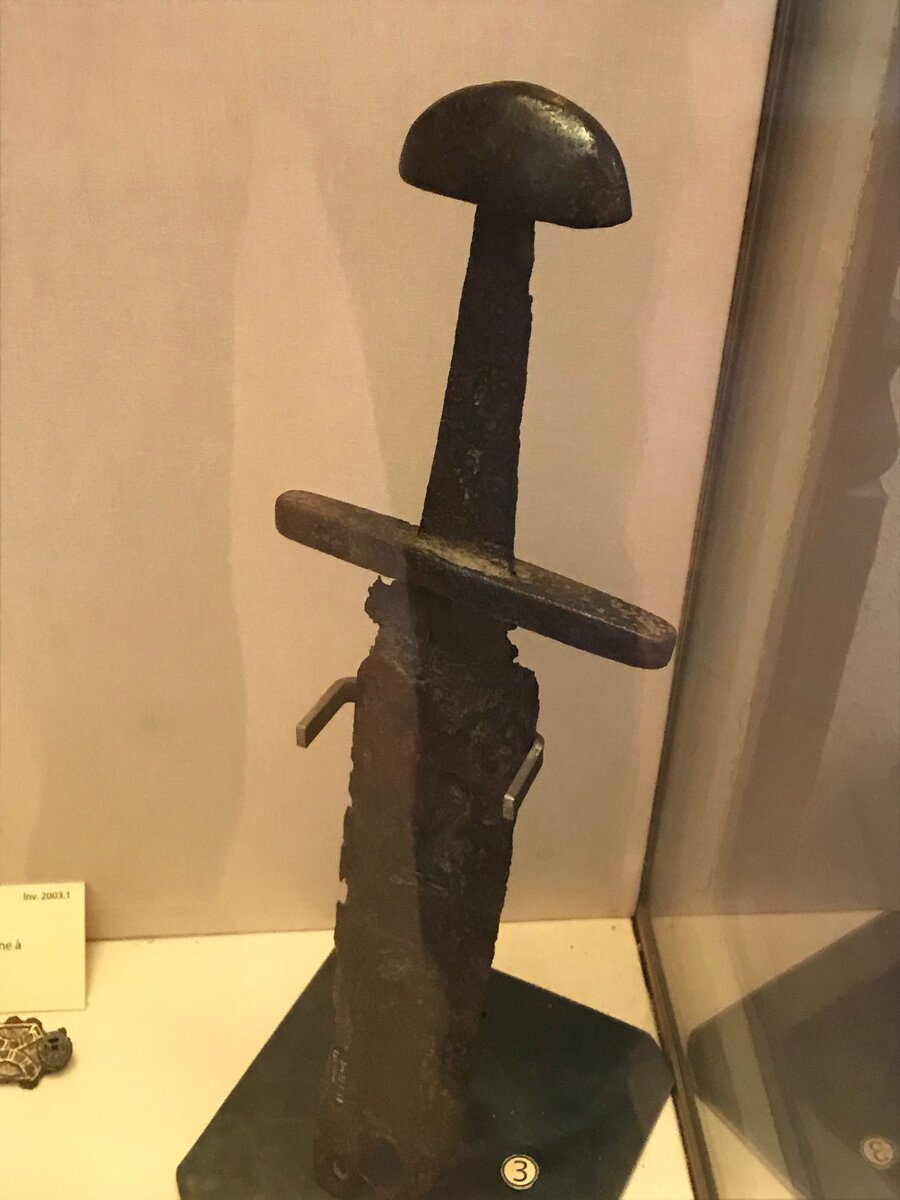 Простой меч эпохи викингов из Руанского исторического музея (фото - "Историк на диване"). Такой простой клинок мог быть использован франкским "ополченцем" или относительно небогатым викингом. Напомним, что такой меч в ножнах стоил, согласно "Рипуарской правде" не менее 7 солидов. 
