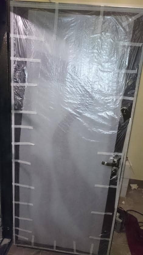 входная дверь в новостройке. защита от пыли при ремонте. пленка для закрытия дверных проемов от пыли. закрыть дверь при ремонте. упакованная входная дверь.