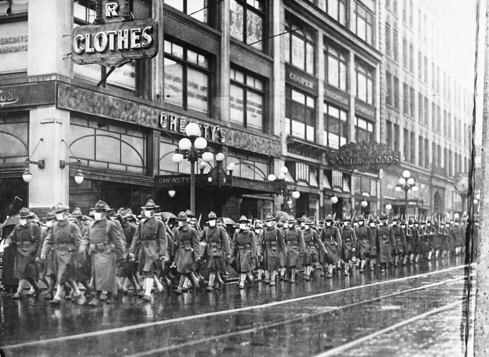 Военные в медицинских масках идут по улицам Сиэтла перед отправкой во Францию National Archives