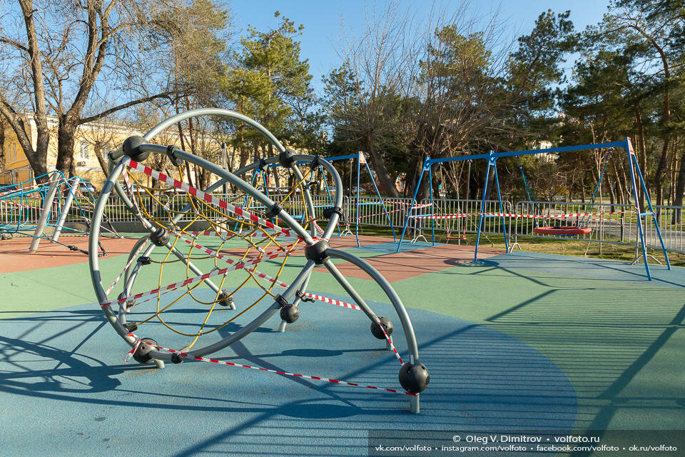 Обвязанные сигнальными лентами игровые площадки в парках и дворах города