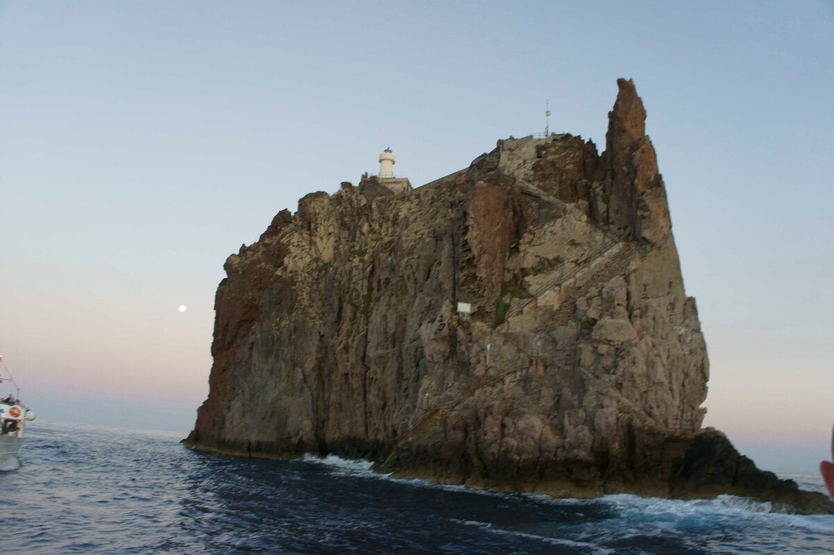 Виды скалы с маяком с катера вечером