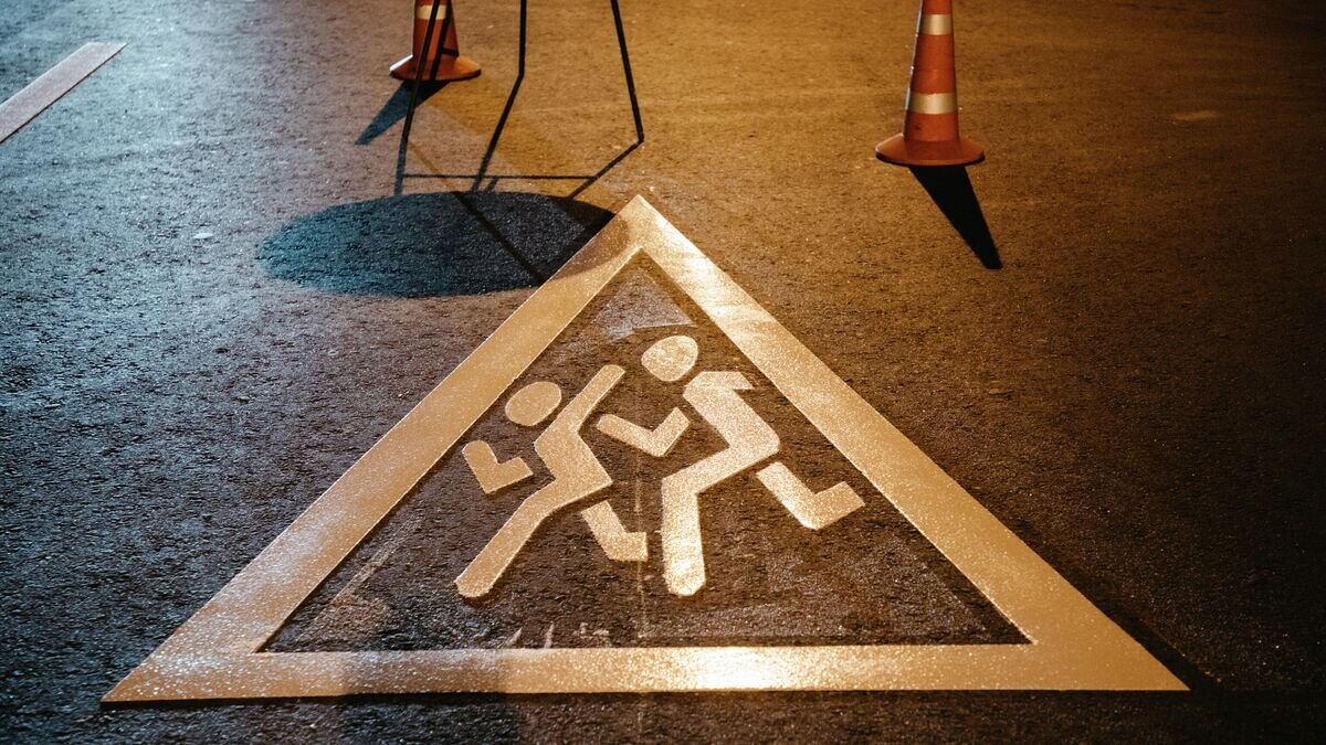    Специалисты комплекса городского хозяйства наносят на дорогу в преддверии знак "Осторожно, дети!© Фото : комплекс городского хозяйства Москвы