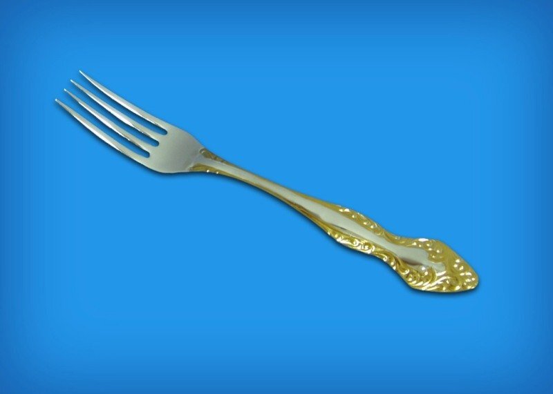 фотография столовой вилки с позолоченной ручкой  на голубом фоне!