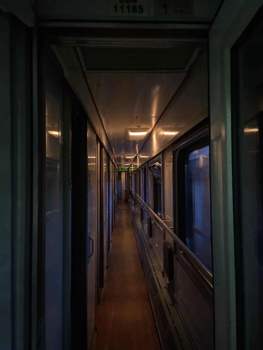 Коридор в вагоне выглядит зловеще-загадочно в тусклом свете ламп