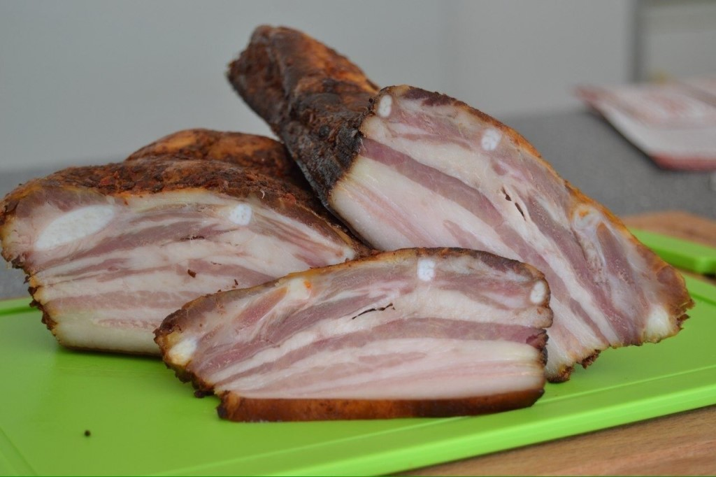  1 кг сала с мясной прослойкой, 
2 головки чеснока, 
3 ст. л. черного молотого перца; 

для рассола: 

2 горсти шелухи репчатого лука, 5 черносливин, 
2 лавровых листа, 
200 г соли, 2 ст. л. сахара. 

Все ингредиенты рассола залейте 1 л воды, доведите до кипения. 

Тем временем тщательно вымойте и обсушите сало, разрежьте его на 2 куска. 

Выложите сало в маринад и варите 25 минут с момента закипания на среднем огне. Оставьте остужаться прямо в рассоле на ночь. Чеснок истолките с перцем. 

Сало выньте из маринада, обсушите, натрите чесночной смесью. Заверните каждый кусочек в пищевую пленку. 

Если планируете съесть сало в течение недели, храните в холодильнике, а для более длительного хранения поместите в морозилку.