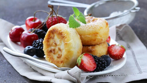 Вам понадобятся: обезжиренный творог, различные ягоды, яйца, ванильный сахар.
Приготовление:  творог перетираем через мелкое сито или используем блендер (это сделает  творог нежным и воздушным), затем выкладываем творог в глубокую миску,  добавляем яйца (1-2 шт.) плюс любые перетертые ягоды и ванильный сахар  (1-2 чайные ложки). Все тщательно перемешиваем. В отдельную тарелку  насыпаем немножко муки (для панировки). Затем начинаем формирование  сырников. После этого выкладываем полученные сырники на противень с  фольгой и запекаем их в духовке (время приготовления 15-20 минут).
Совет: Чтобы сырники получились радужными, необходимо смешивать их с разными ягодами в отдельной тарелке!