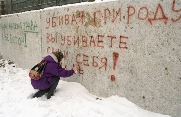 Жительница Москвы пишет на бетонном заборе протест против строительства здания на месте сквера, ноябрь 1996 год.