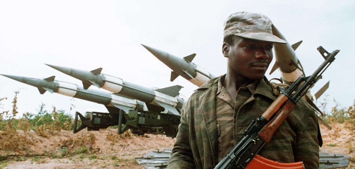 Ангольский солдат с автоматом Калашникова перед советскими зенитными ракетами.