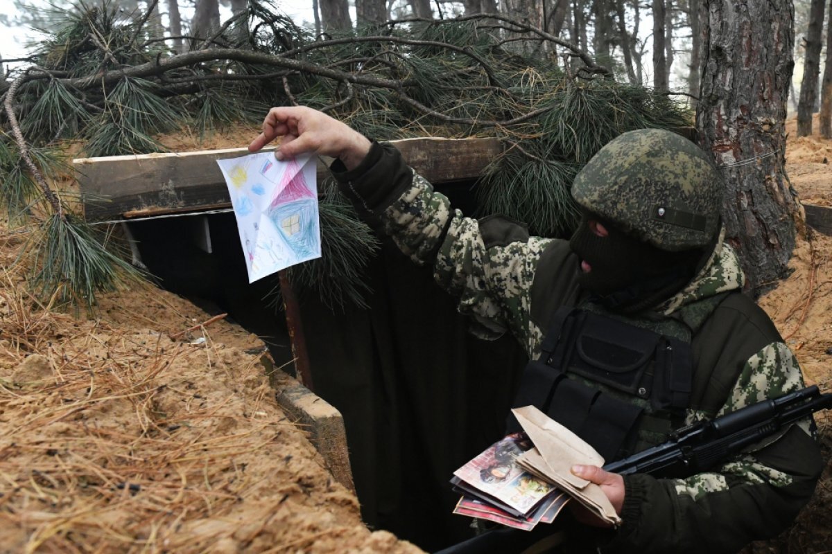    Военнослужащий, призванный в рамках частичной мобилизации, смотрит письма и рисунки детей, переданные журналистами РИА Новостей, на военной позиции в районе города Энергодар Запорожской области.