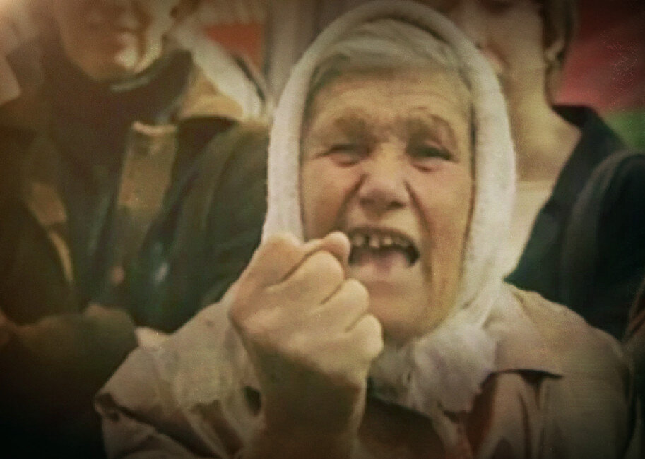 Бабушка в платке грозит кулаком