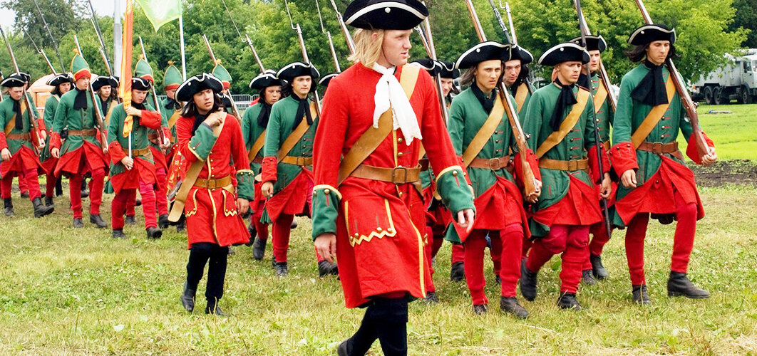 Современные реконструкторы в форме Преображенского полка начала XVIII века. Примерно так выглядели петровские солдаты на марше, при выступлении из Москвы.