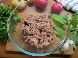 
Далее добавляем в фарш специи, травы. Кладем нарезанное кусочками размягченное  сливочное масло. Затем  еще раз хорошо перемешиваем. После этого добавляем бульон или воду. Наконец, снова вымешиваем фарш. Отставляем его в сторону - лучше в холодное место.